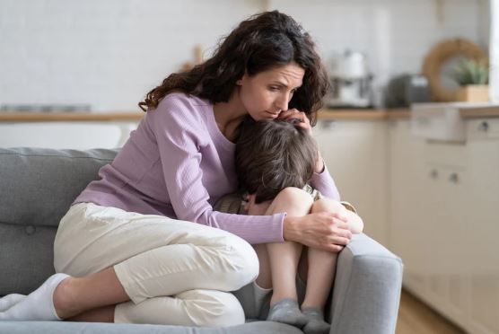 Parent comforting a child with anxiety at home while supporting learning needs