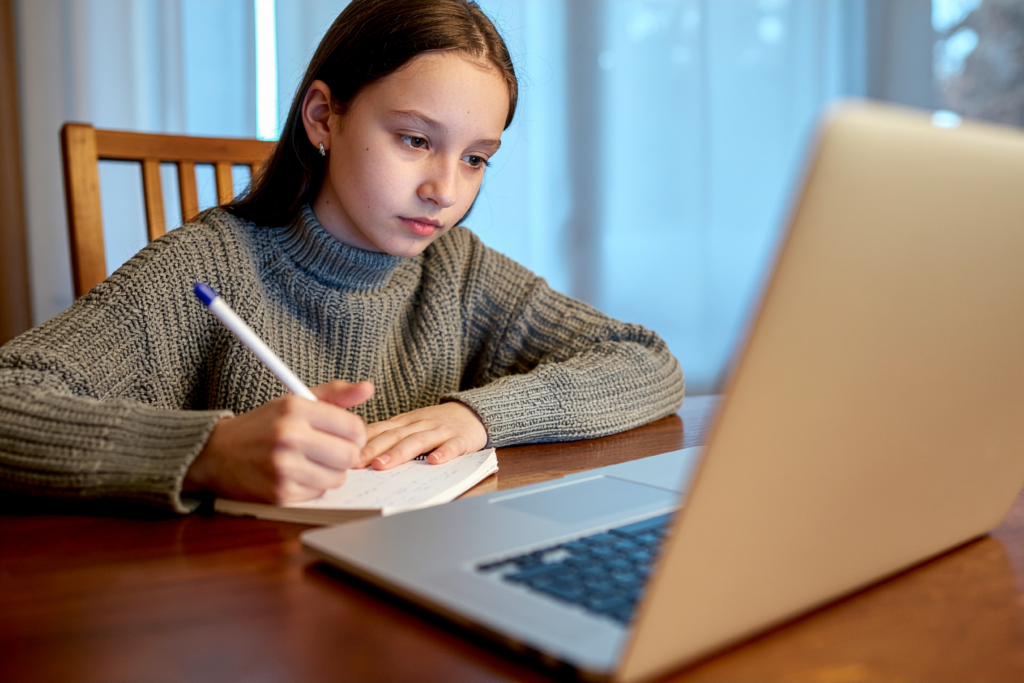 Homeschooling study setup with laptop, books, and handwritten notes.